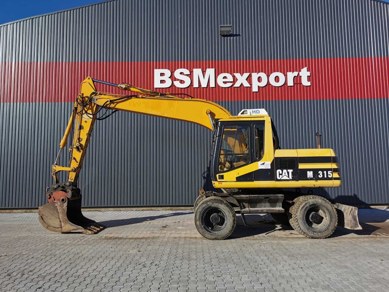 Caterpillar M315 wheel excavator - Excavadora de ruedas: foto 1 Caterpillar M315 wheel excavator - Excavadora de ruedas: foto 1